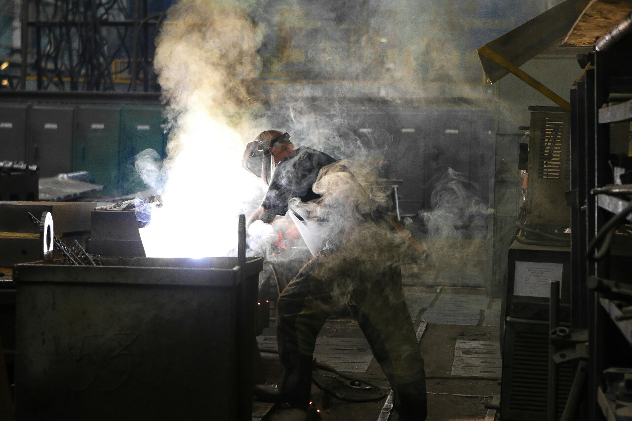 a person is welding at a work table, metal forming a metal workpiece